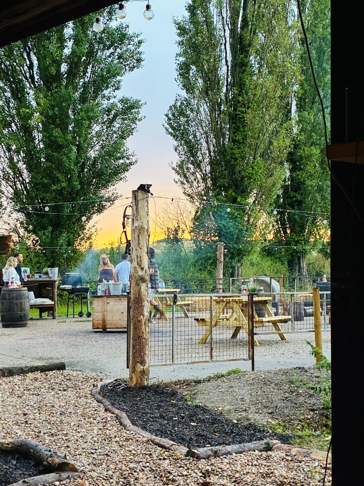 Guests gathered in the Branding Pen outdoor BBQ and recreation area at sunset